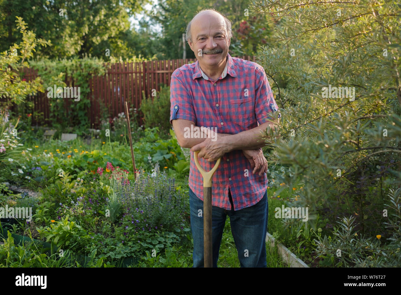 Älterer Mann mit einem Schnurrbart, stehen im Sommer Garten, lächelnd. Stockfoto