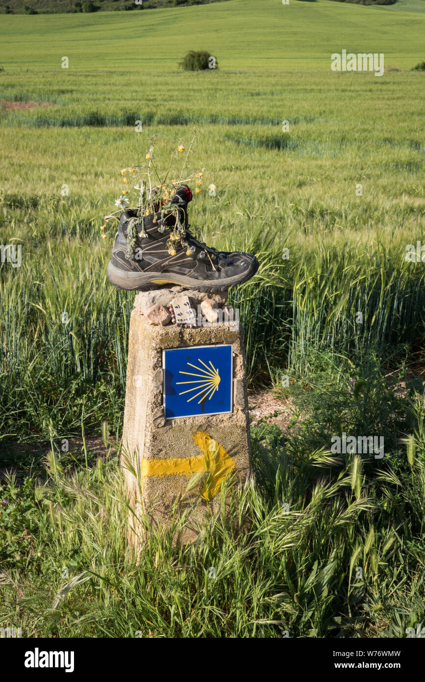 Wandern Schuh links auf einen Kilometer Markierung mit einem gelben Pfeil und eine stilisierte gelbe Muschel auf blauem Hintergrund, Logo der kulturellen Route des Rates Stockfoto