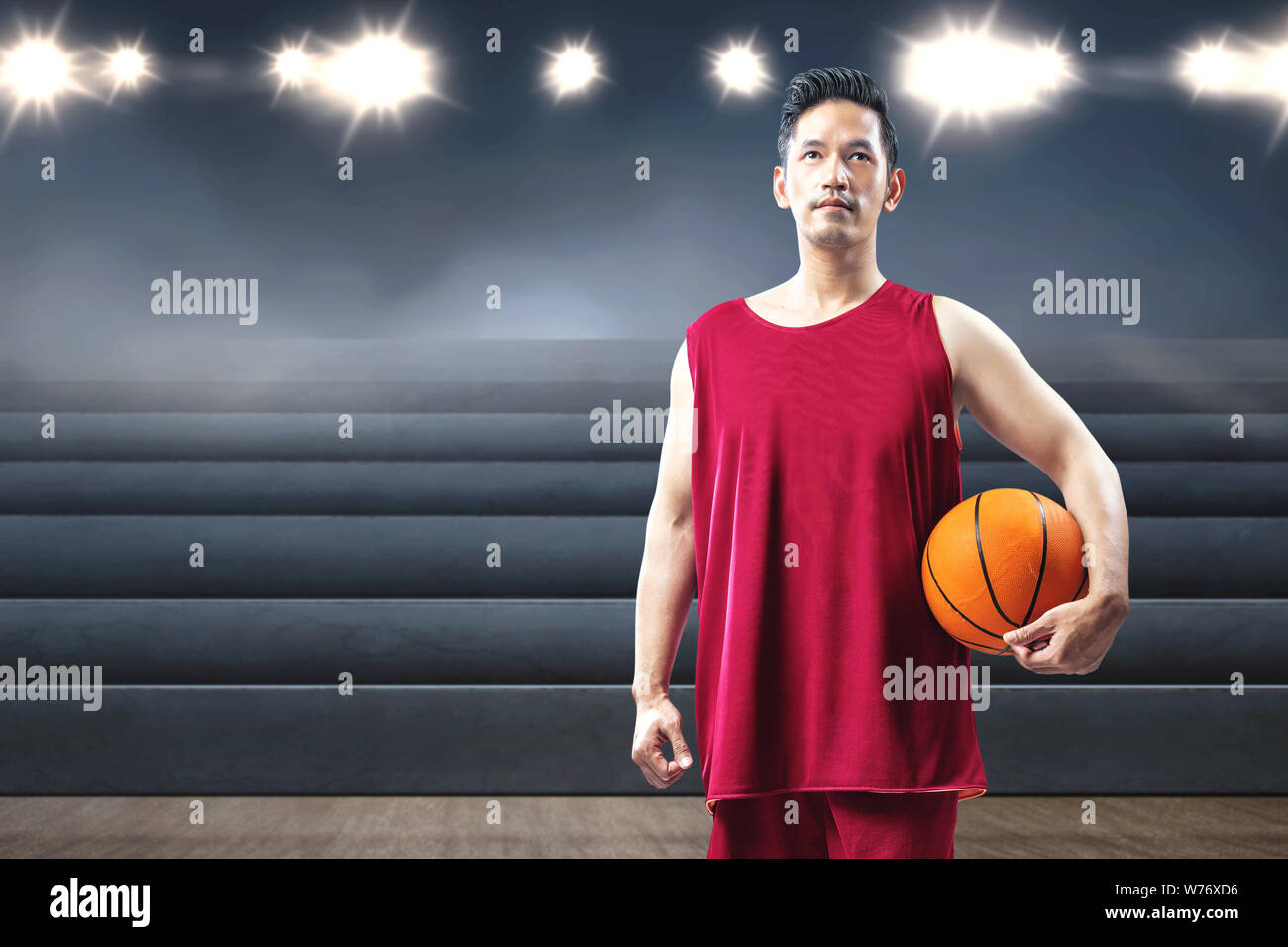 Asiatischer mann Basketball Spieler, der den Ball auf seine Hand auf den Indoor Basketball Court Stockfoto