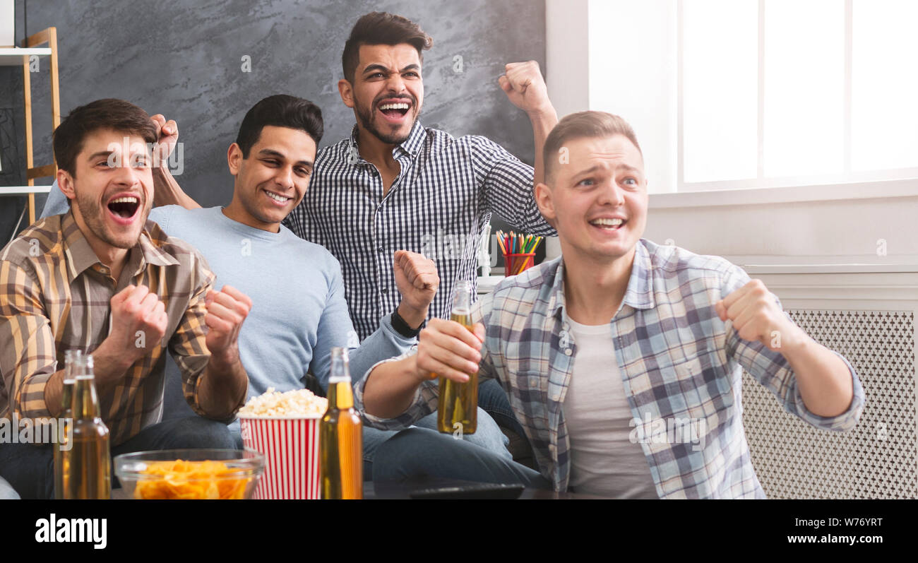 Freundliche männliche Freunde feiern den Sieg ihrer Lieblingsmannschaft Stockfoto
