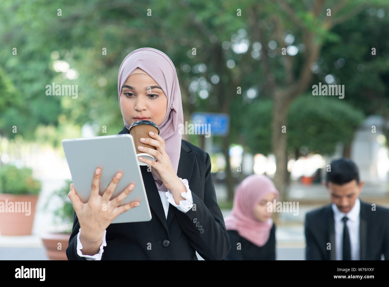Muslimische business Frau trinkt Kaffee beim Gehen am Morgen zu arbeiten. Stockfoto