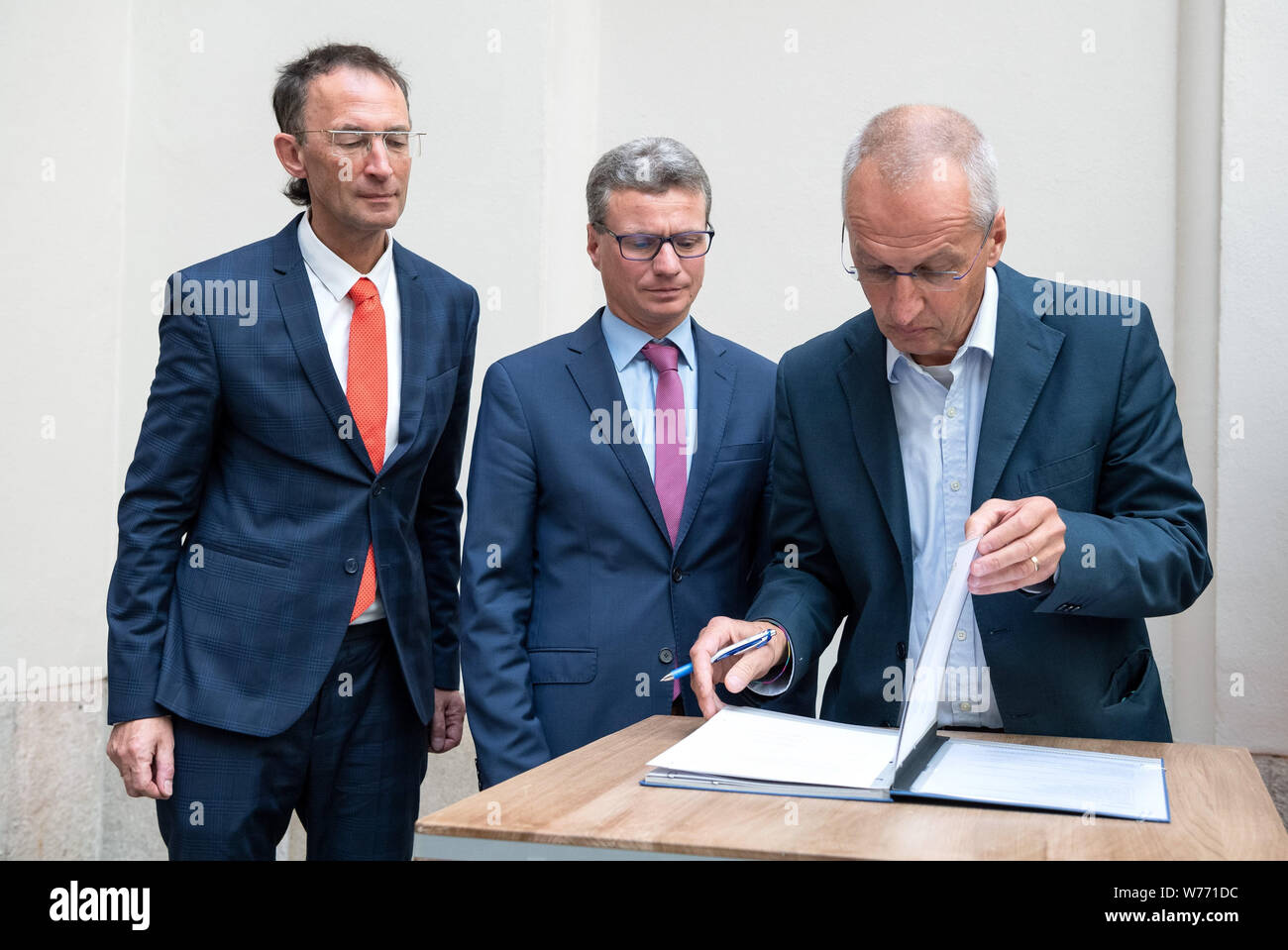 München, Deutschland. 05 Aug, 2019. Frank Matthias Kammel (L-R), Generaldirektor des Bayerischen Nationalmuseums, Bernd Sibler (CSU), Bayerischer Staatsminister für Wissenschaft und Kunst und Hardy Langer, Vertreter der Erbengemeinschaft, Zeichen der Restitution der Vereinbarung. Fünf Gemälde, drei Farbe Gravuren und eine hölzerne Verkleidung wurde durch die Gestapo im November 1938 beschlagnahmt. Die Münchner Sammlungen haben nun die Werke an die Erben von Julius und Simone Davidsohn aus München zurück. Credit: Sina Schuldt/dpa/Alamy leben Nachrichten Stockfoto