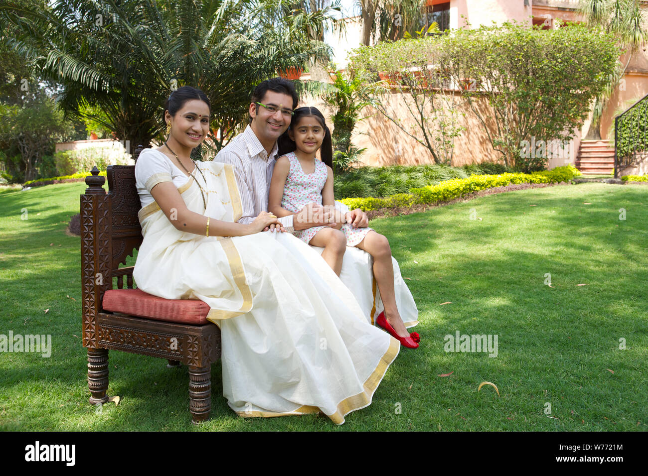 Südindische Familie Zusammensitzen im Rasen Stockfoto