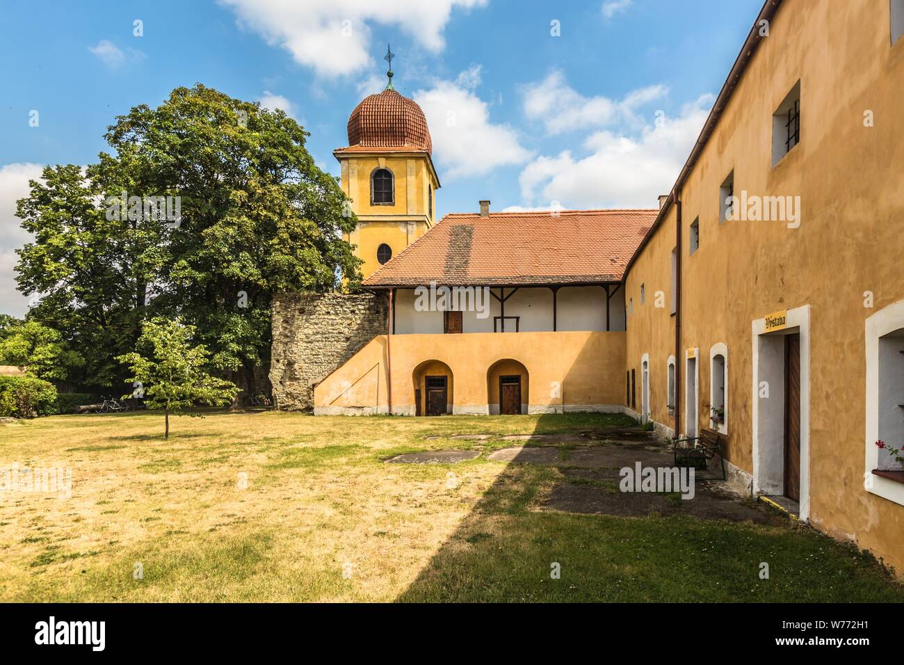 Panensky Tynec, Tschechische Republik - 15. Juli 2019: Gelb Glockenturm und ehemaliges Kloster der Klarissen, heute der Stadtverwaltung. Sonnigen Tag. Stockfoto