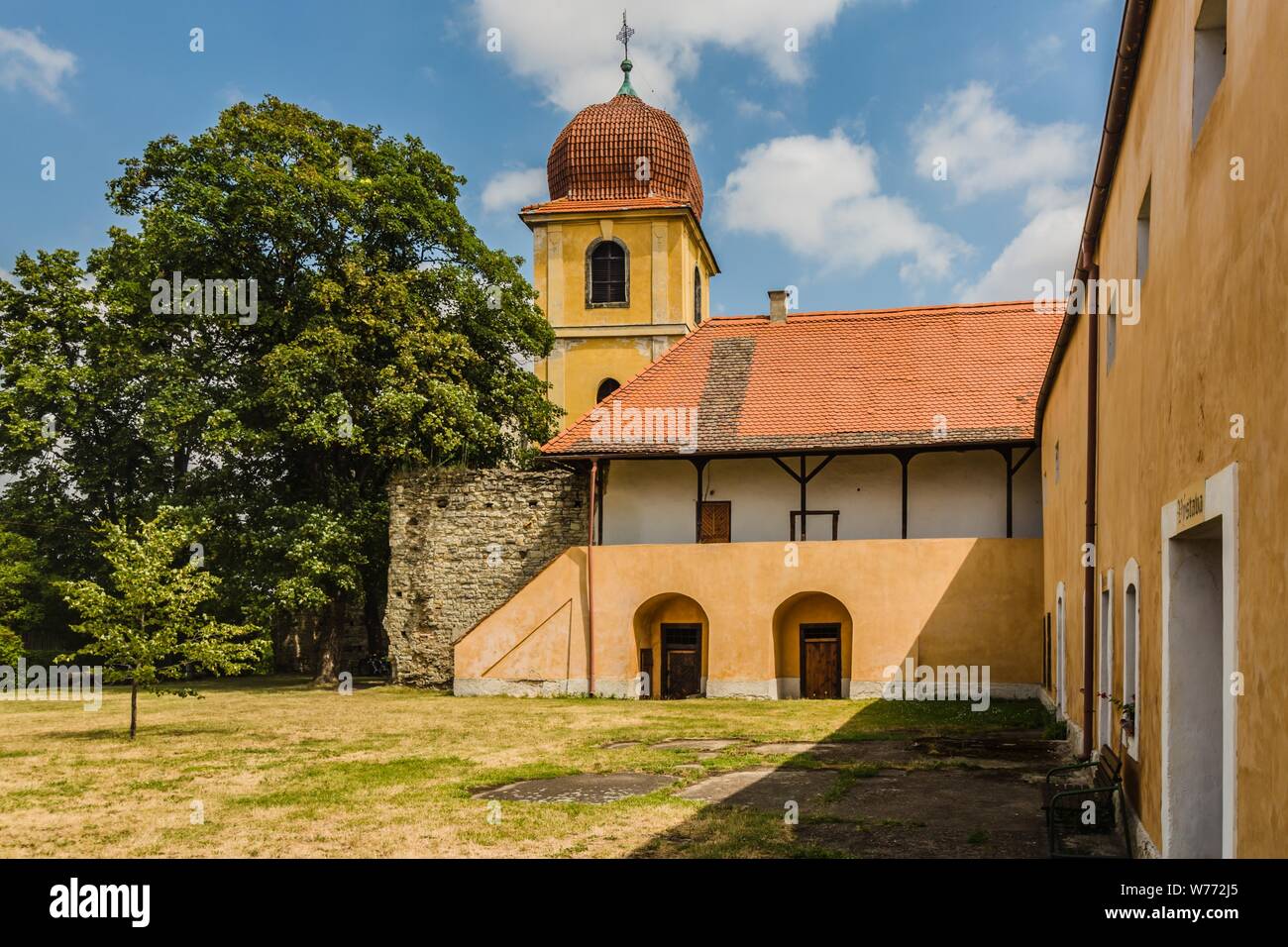 Panensky Tynec, Tschechische Republik - 15. Juli 2019: Gelb Glockenturm und ehemaliges Kloster der Klarissen, heute der Stadtverwaltung. Sonnigen Tag. Stockfoto