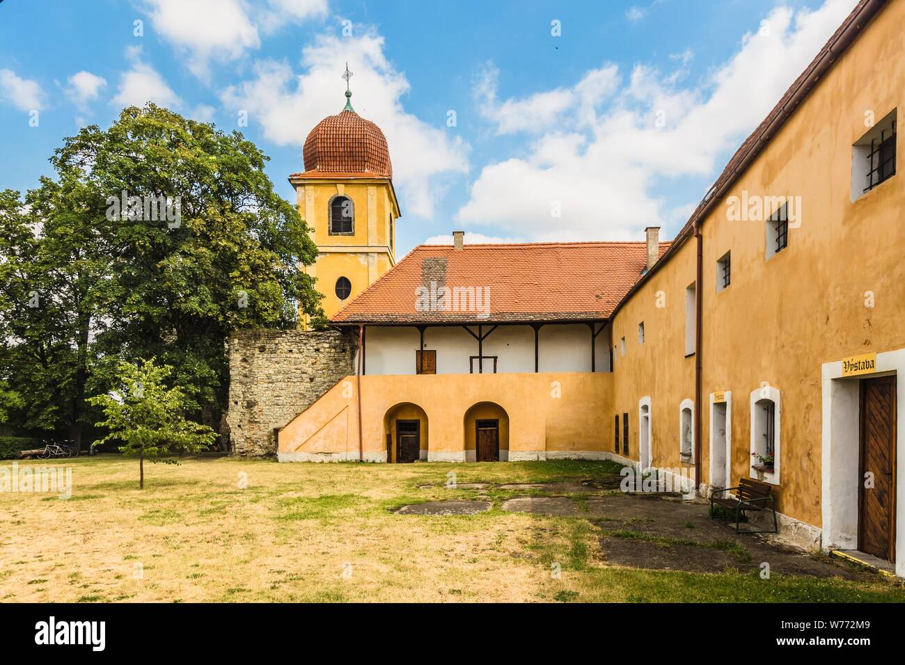 Panensky Tynec, Tschechische Republik - 15. Juli 2019: Gelb Glockenturm und ehemaliges Kloster der Klarissen, heute der Stadtverwaltung. Sonnigen Tag. Stockfoto