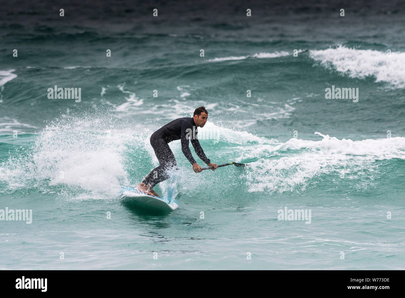 Ein Stand up Paddle boarder an Fistral in Newquay in Cornwall. Stockfoto