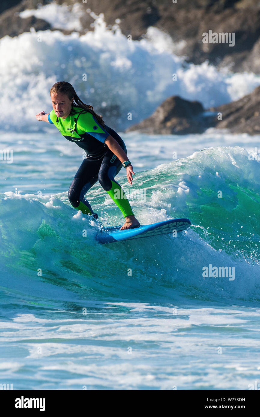 Eine weibliche Surfer auf einer Welle an Fistral in Newquay in Cornwall. Stockfoto