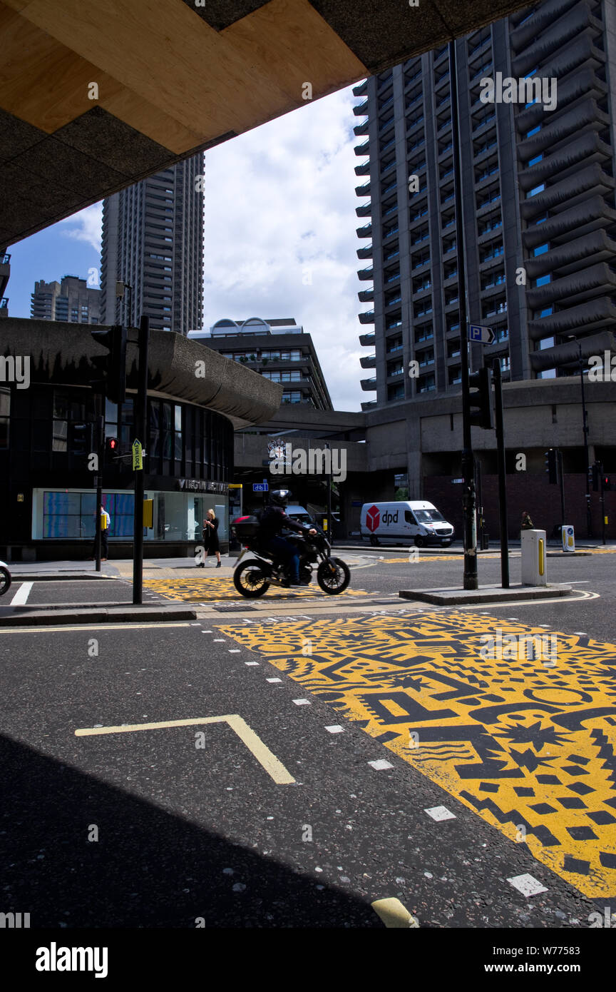 Der Verkehr fließt über eine eingerichtete Kreuzung außerhalb der U-Bahnhof Barbican in London, UK. Stockfoto