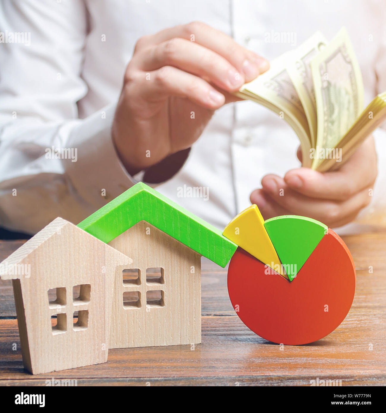 Häuser mit Kreisdiagrammen und ein Mann zählen Geld. Forschung der Immobilien Markt- und Preisentwicklung. Haushalt, Wartungskosten, Utilities, Rechnungen. Ener Stockfoto