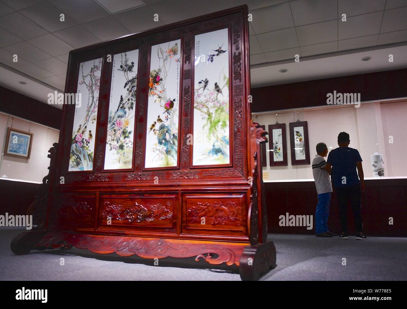 (190805) - NANCHANG, August 5, 2019 (Xinhua) - Mao Guanghui (L) stellt seine Kreationen zu einem Besucher in der Ausstellungshalle eines keramischen Forschungsinstitut in Jingdezhen, der ostchinesischen Provinz Jiangxi, 31. Juli 2019. Mao Guanghui, eine 56-jährige Senior Master für Kunst und Handwerk in der Provinz Jiangxi, widmet sich auf Porzellan Malerei seit dem Alter von 13. Als dritte Generation der Schüler von Deng Bishan (1874-1930), einem der Acht Freunde von Zhushan', eine Gruppe von jingdezhen Handwerker bekannt für ihre Innovationen in der porzellanmalerei festgestellt, Mao geerbt hat nicht nur die Fähigkeiten, sondern auch t Stockfoto