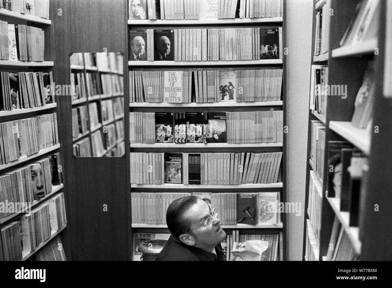 Buchhandlung aus den 1970er Jahren London Mann in Regalen mit Büchern. 70ER JAHRE UK HOMER SYKES Stockfoto