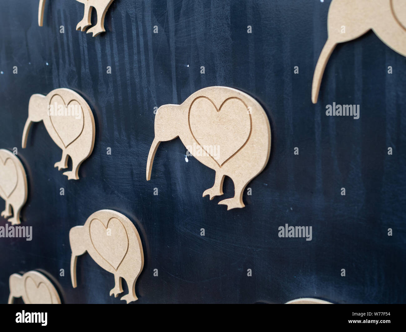 Kunstwerke in Christchurch, Neuseeland, das Symbol der Kiwi Vogel mit Herzen Symbole auf ihnen, aus Holz auf einem schwarzen Hintergrund Stockfoto