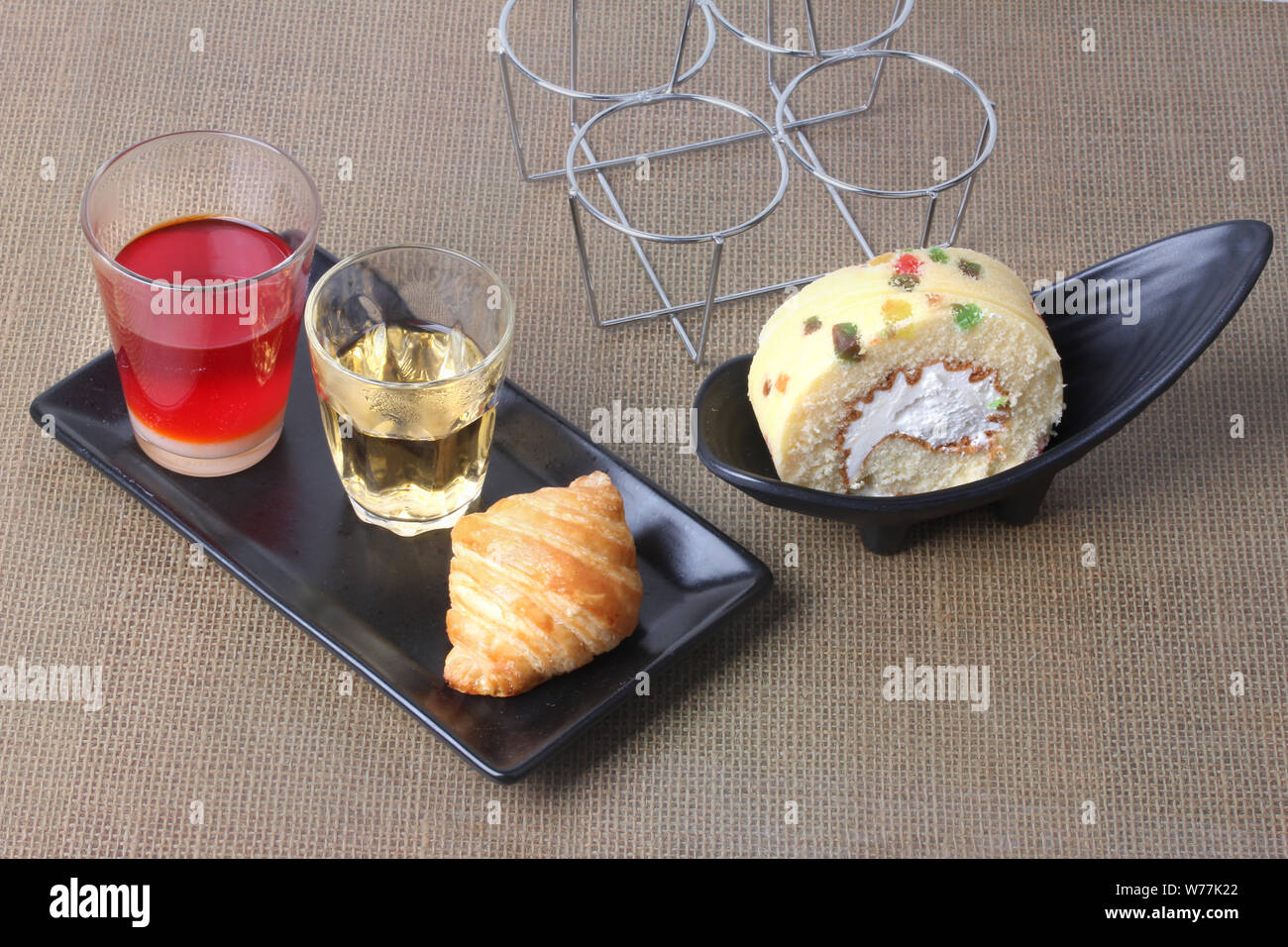 Traditionelle thailändische Milch Kaffee serviert mit Kaffee, Croissants und Obst Kuchen auf altem Holz serviert. Stockfoto