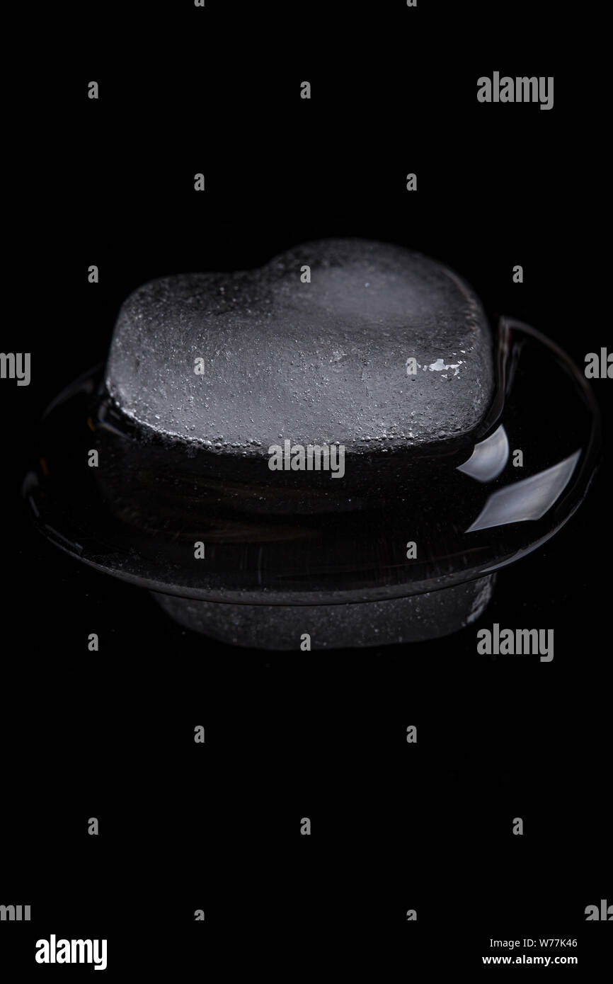 Herzförmige ice Rock in der Nähe auf einem schwarzen Hintergrund Stockfoto