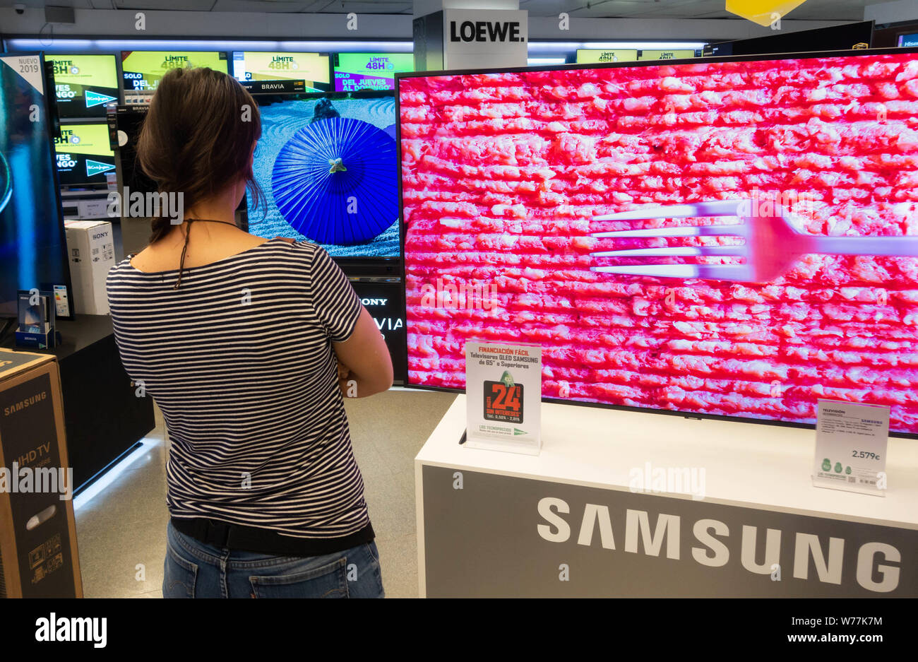Frau auf der Suche nach neuen Samsung HD 4k gekrümmte Bildschirme in elektrischen Speichern Stockfoto