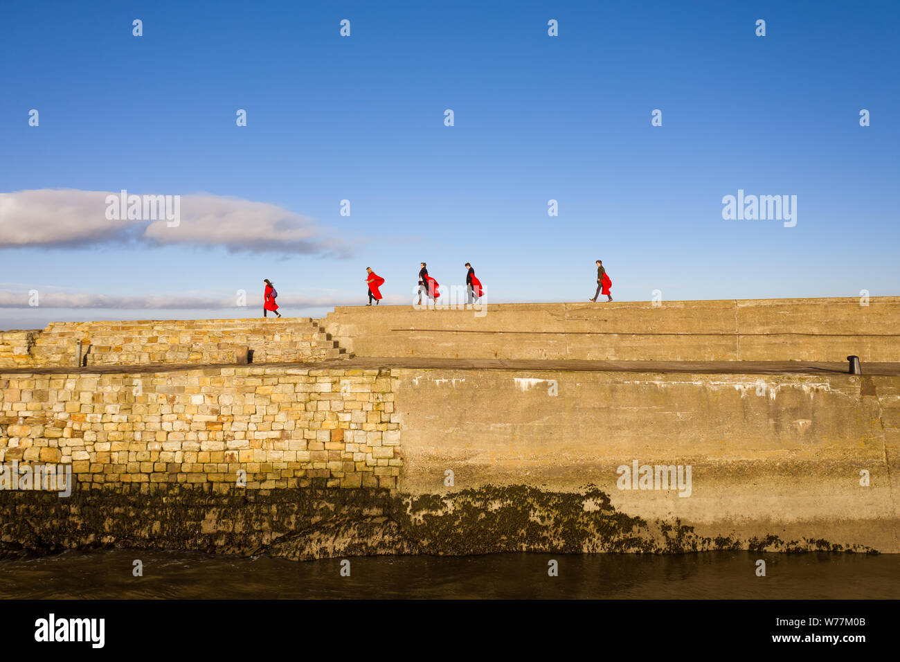 Fünf Studenten an der St. Andrews University führen Sie die berühmten 'Pier zu Fuß" in Ihrer einzigartigen roten Roben gekleidet. Diese Tradition findet jeden Sonntag. Stockfoto