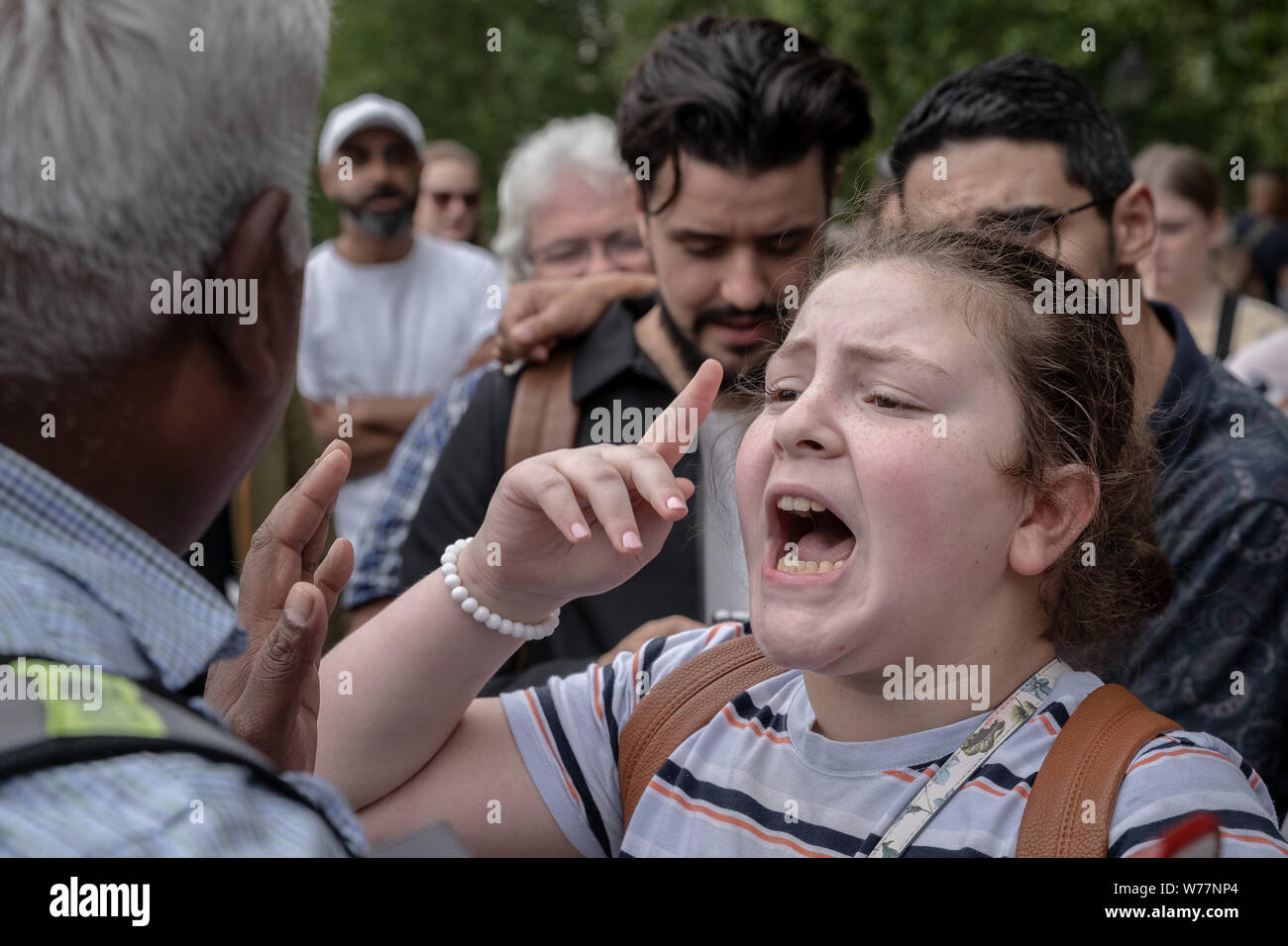Ein 12-jähriger Heckler (R) nimmt auf einer religiösen Sprecher. Die Predigt, die Debatten und Predigten an der Speakers' Corner, das öffentliche Sprechen Ecke des Hyde Park. Stockfoto