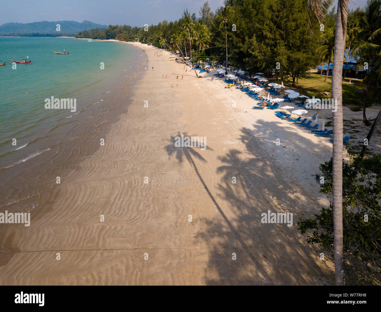 Antenne drone Blick auf einen langen Schatten einer Palme cast auf einen wunderschönen, tropischen Strand leer Stockfoto