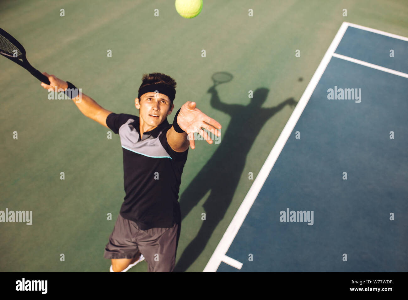 Blick von oben auf die jungen Mann in Sportkleidung, Werfen der Kugel für die dienen. Tennis Spieler den Ball in einem Spiel dienen. Stockfoto