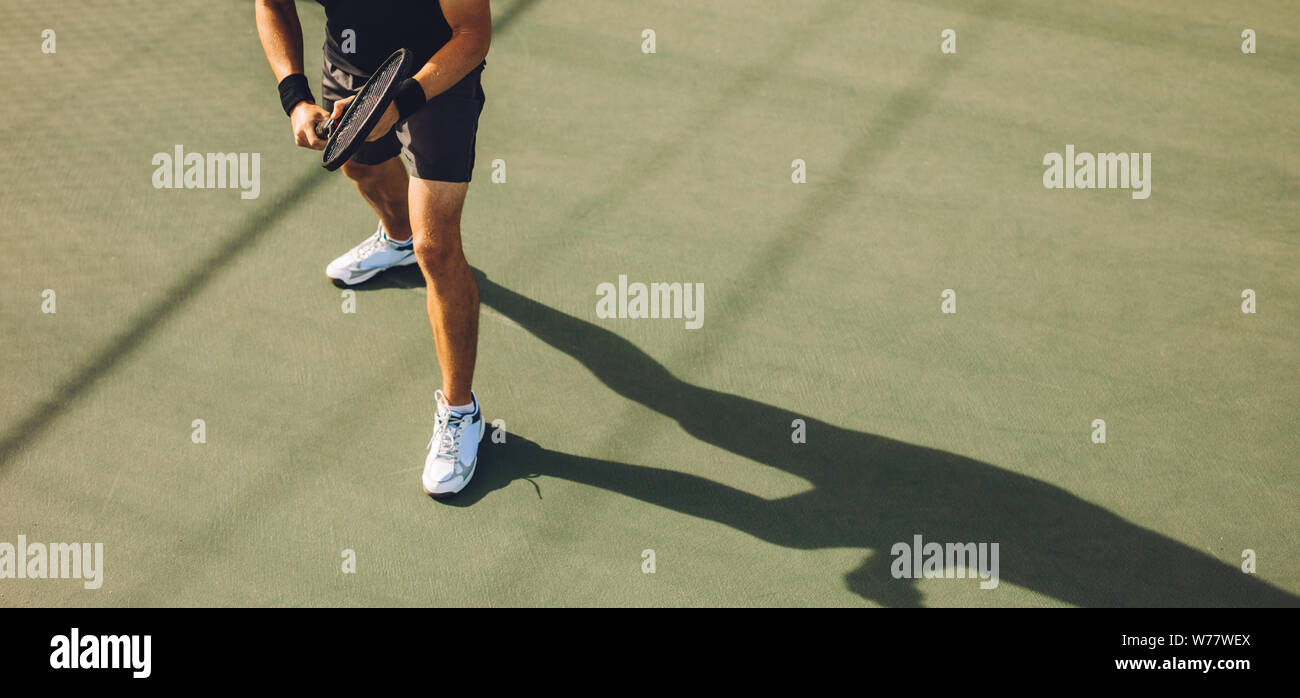 Tennis Player Tennis auf Hartplatz. Junger Mann in Sportbekleidung stehen auf harten Tennisplatz bereit zurückzukehren, die während eines Spiels dienen. Stockfoto