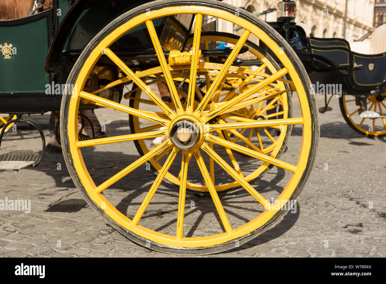 Eine Nahaufnahme des gelben Räder eines traditionellen Pferdekutsche in Sevilla, Spanien Stockfoto