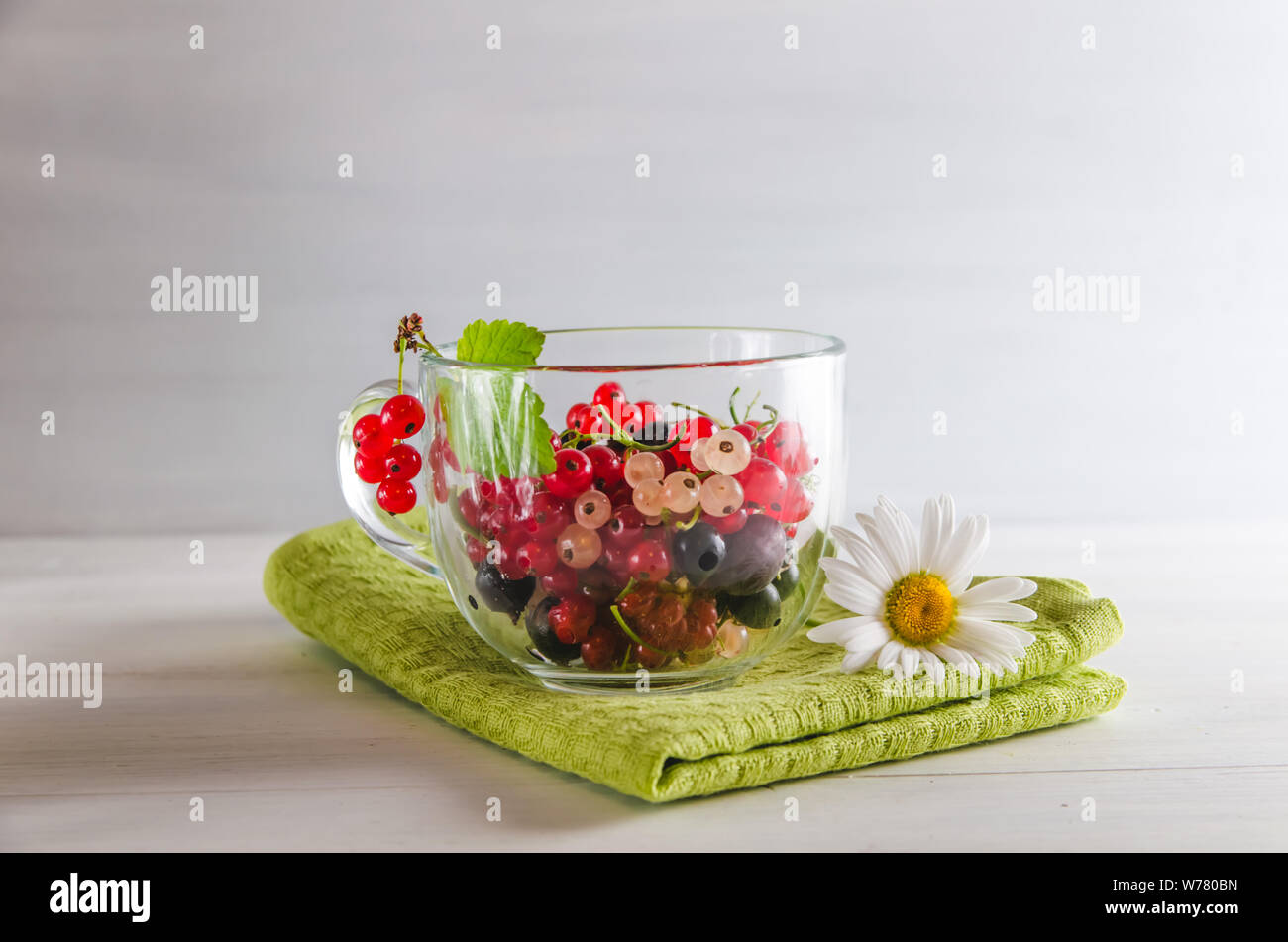 Frische bunte Johannisbeere Beeren in einem Becher auf weißem Hintergrund Stockfoto