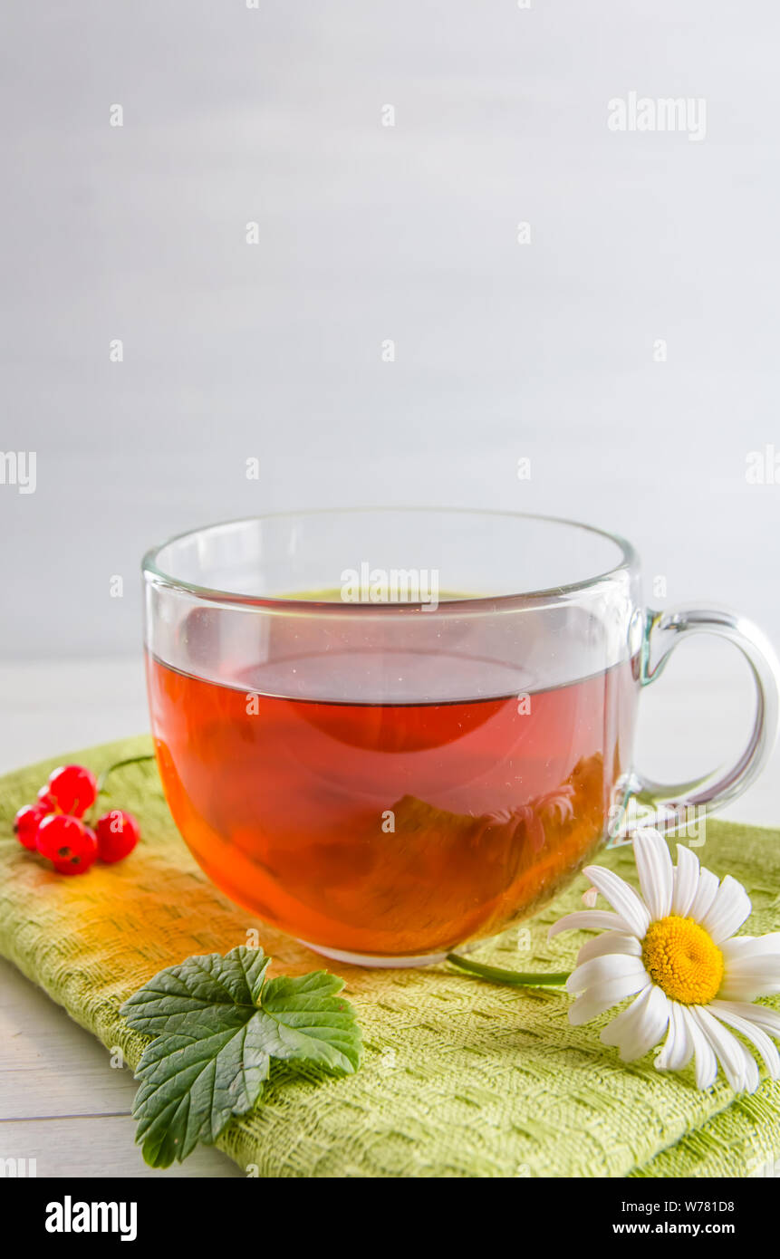 Tee in eine Tasse mit Beeren und Kamille auf weißem Hintergrund mit Kopie Raum Stockfoto