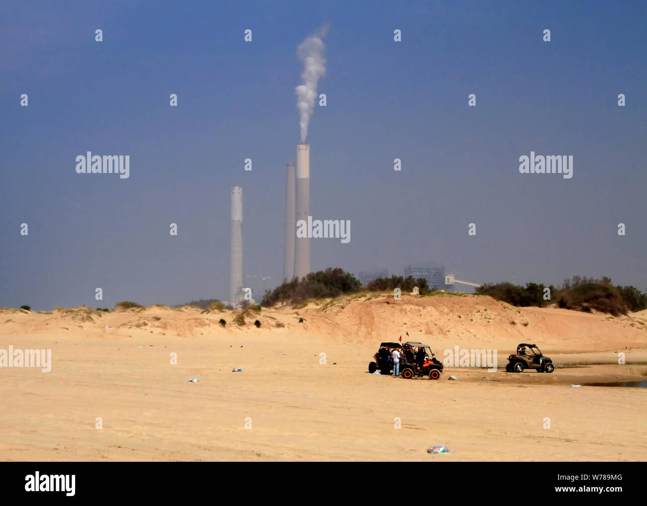 Dune Buggys auf zikim Strand an der Mittelmeerküste in Israel sitzen vor dem rutenberg Kraftwerk Schornsteinen. Stockfoto