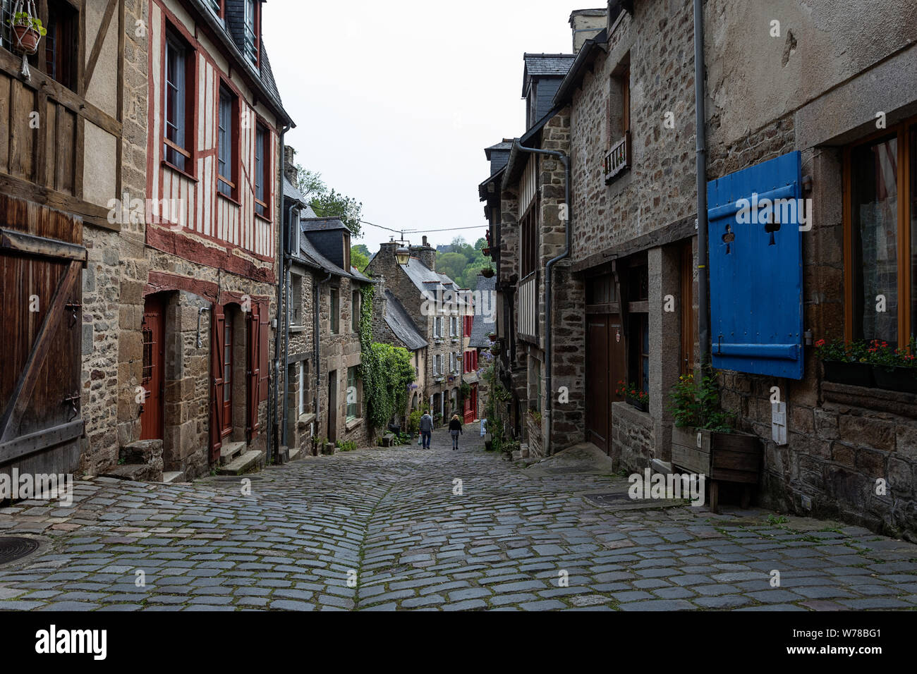 Malerische Straße mit Kopfsteinpflaster und alten Fachwerkhaus und Stein Gebäude Gebäude in der Altstadt von Dinan in der Bretagne, Frankreich Stockfoto