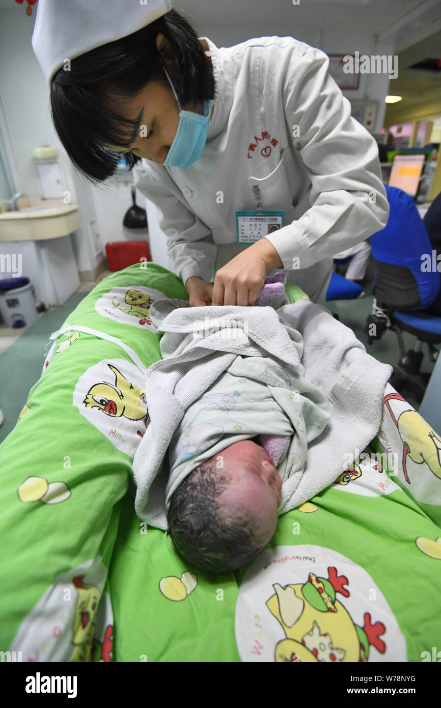 Eine Krankenschwester kümmert sich um die gesunde Mädchen baby Born durch chinesische Frau Wei Chunlan per Kaiserschnitt, der gerade ein wenig mit Zwerg über drei Meter hoch Stockfoto