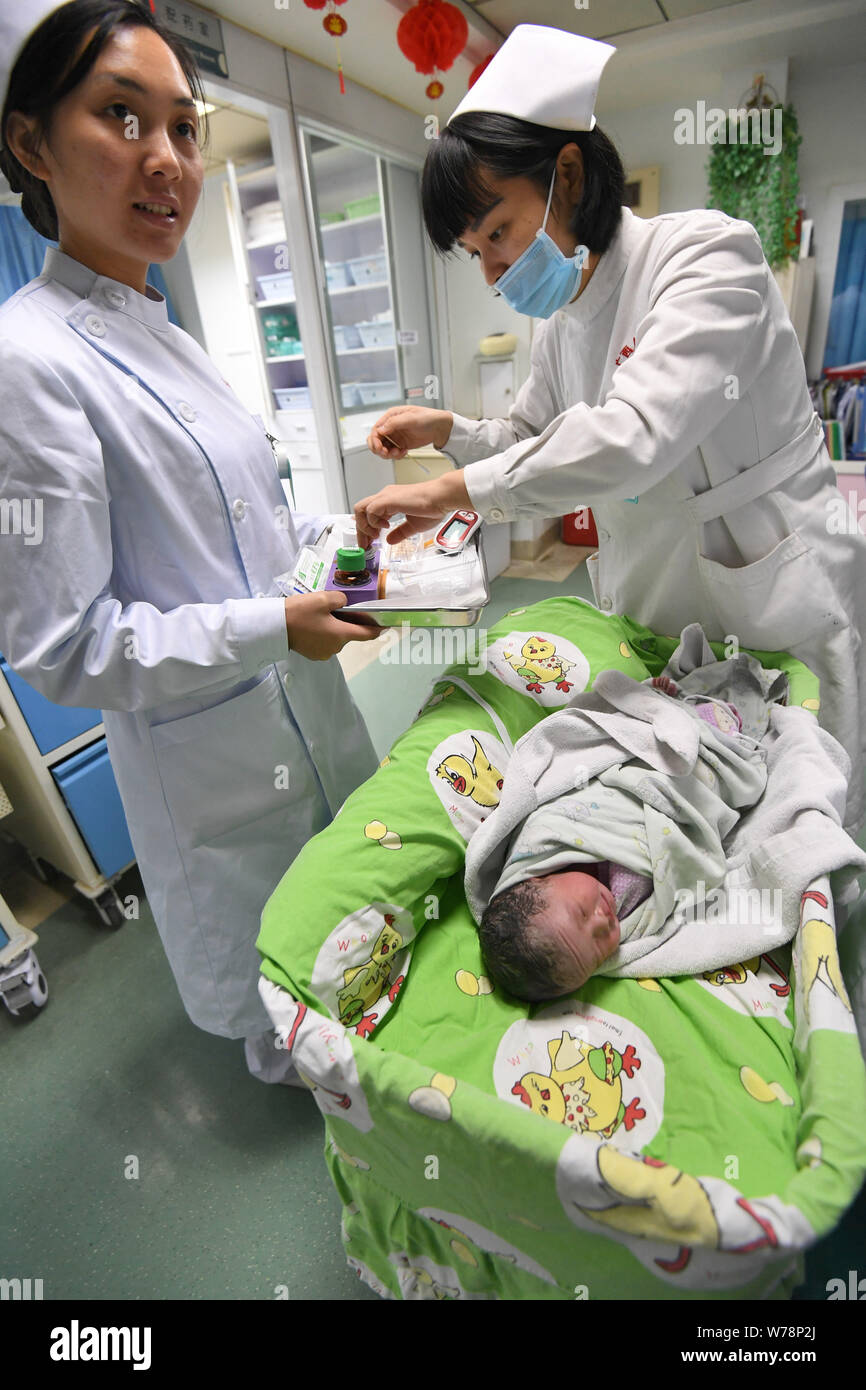 Krankenschwestern kümmern sich um die gesunden Mädchen baby Born durch chinesische Frau Wei Chunlan per Kaiserschnitt, die nur etwas mehr als drei Meter hoch mit dwarfis Stockfoto