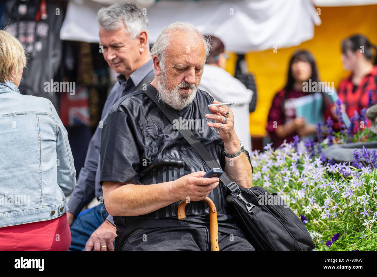 Cambridge, UK, 1. August 2019. Bärtige ältere Menschen gechillt und das Rauchen auf der Straße Stockfoto
