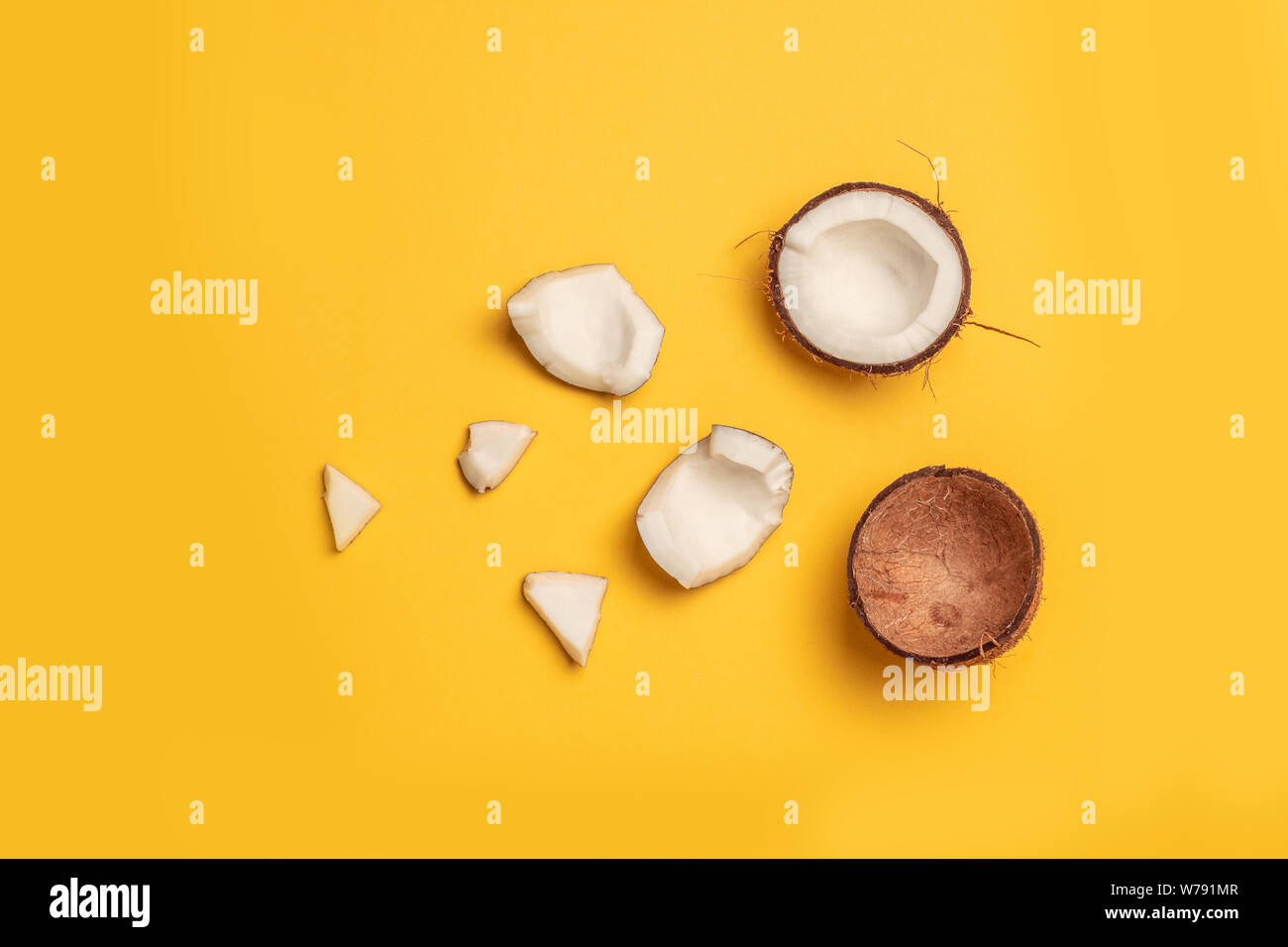 Coconut Muster. Frische Kokosnüsse auf gelben Hintergrund. Flach, Ansicht von oben Stockfoto