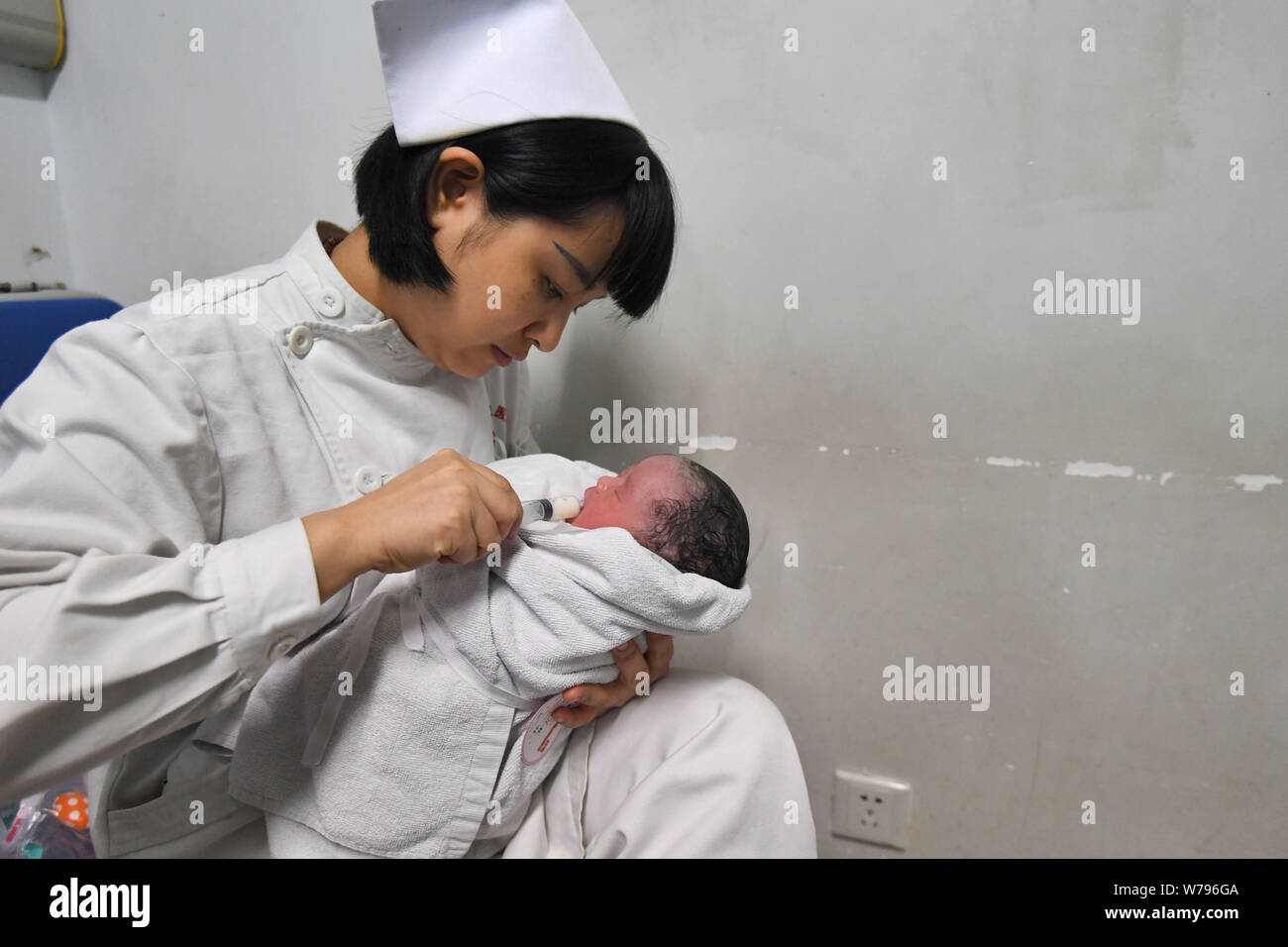 Eine Krankenschwester kümmert sich um die gesunde Mädchen baby Born durch chinesische Frau Wei Chunlan per Kaiserschnitt, der gerade ein wenig mit Zwerg über drei Meter hoch Stockfoto