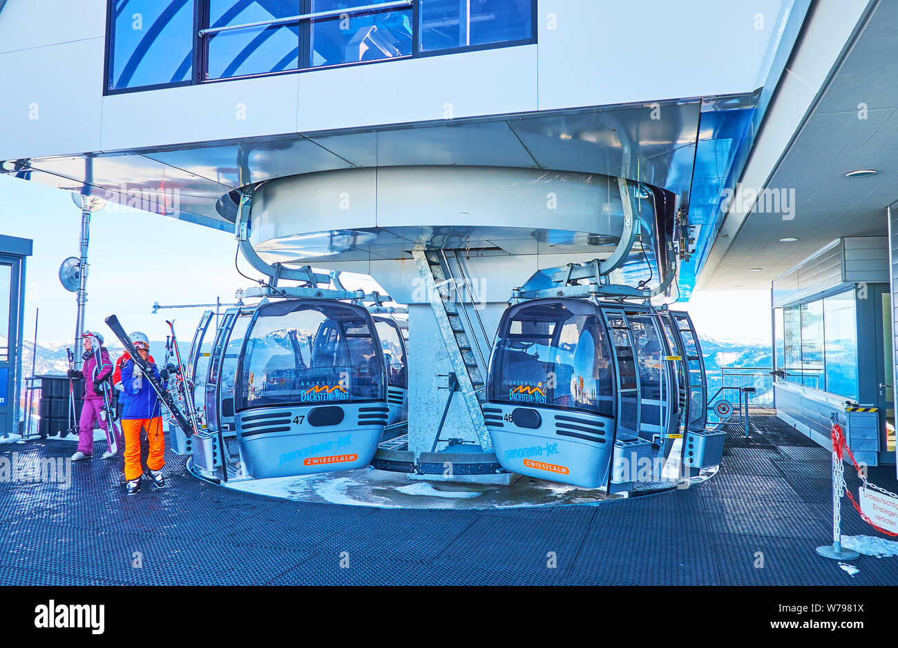 GOSAU, Österreich - Februar 26, 2019: Das sich drehende Gondeln auf der oberen Station der Seilbahn Panorama Jet Zwieselalm mit Skifahrer, zu Pisten, t Stockfoto