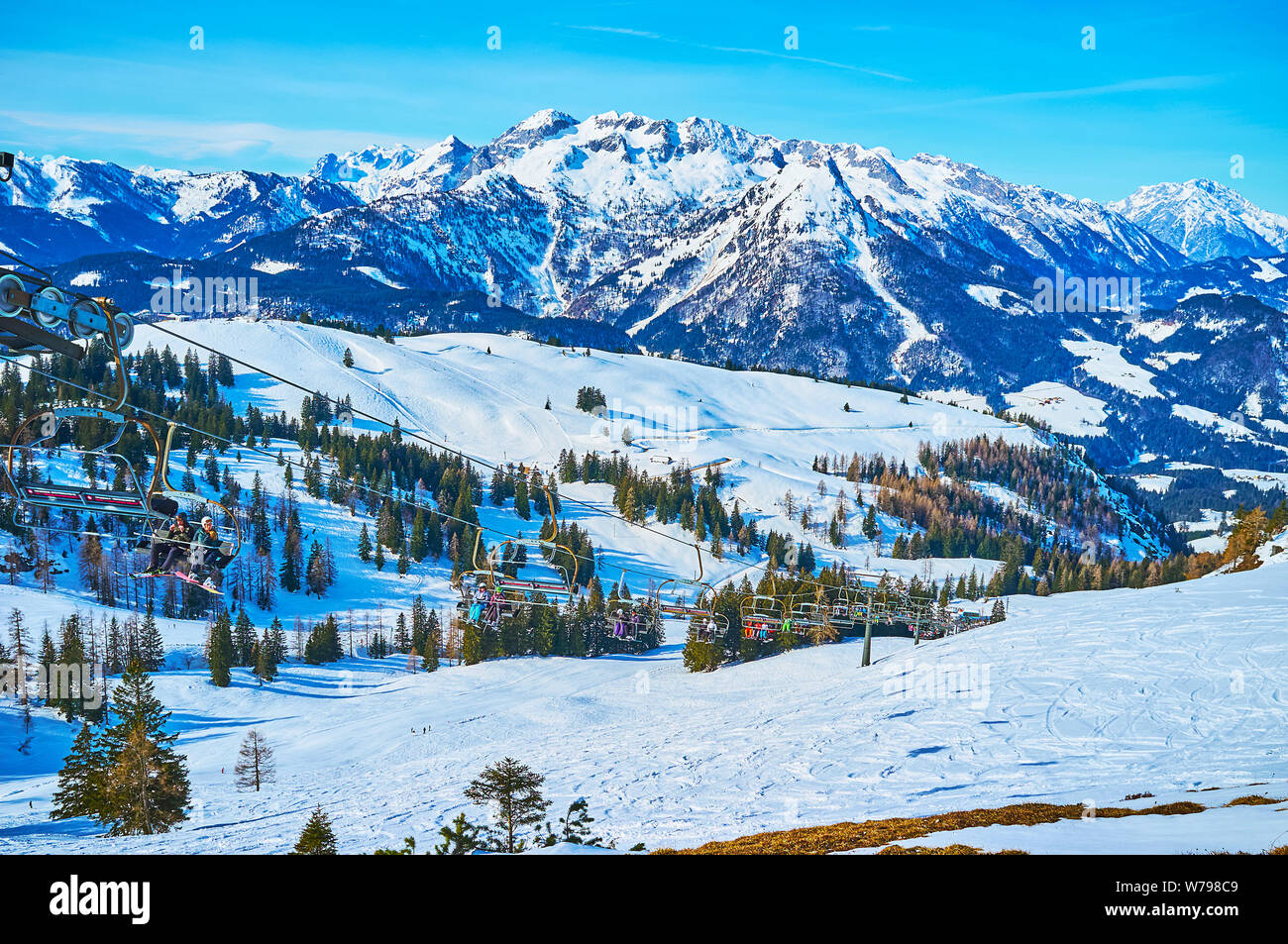 GOSAU, Österreich - Februar 26, 2019: Der Sessellift, Reiten entlang der schneebedeckten Hang der Zwieselalm Berg, mit Blick auf die Gipfel der Alpen Dachstein West auf Th Stockfoto