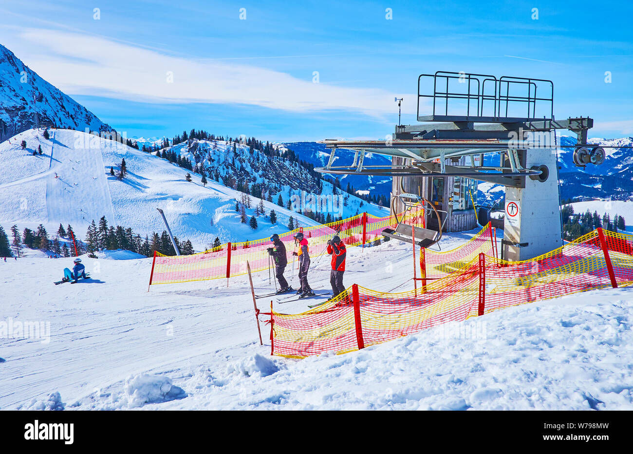 GOSAU, Österreich - Februar 26, 2019: Von der Bergstation der Sesselbahn, die von felsigen Dachstein West Alpen umgeben, die Kabinen durchführen Skifahrer an der Spitze der Z Stockfoto