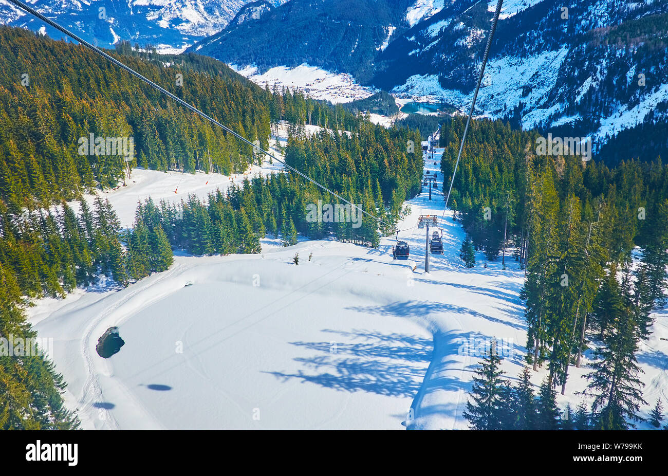 Die Gondel von Air Lift Fahrten über die winzigen gefrorenen See, am Hang des Berges Zwieselalm, mit weißen Schnee, Gosau, Salzkammergut, Austr Stockfoto