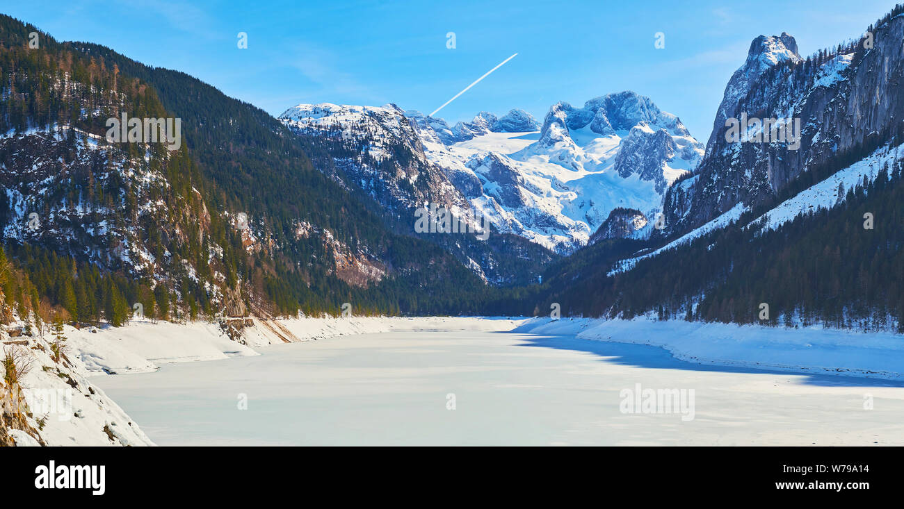 Spaziergang durch gefrorene Gosausee mit Dachstein Alpen mit üppigen Bäumen und scharfen felsigen Gipfeln Fichte, Gosau, Salzkammergut, Österreich umgeben. Stockfoto