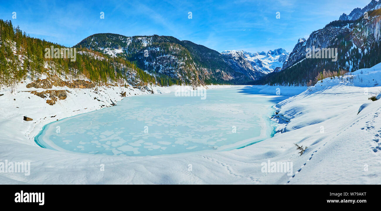 Panorama der Flauschig verschneiten Deich Gosausee, die mit Eis und Raureif überzogen ist und durch die sehr großen Dachstein Alpen umgeben, Gosau, Austr Stockfoto
