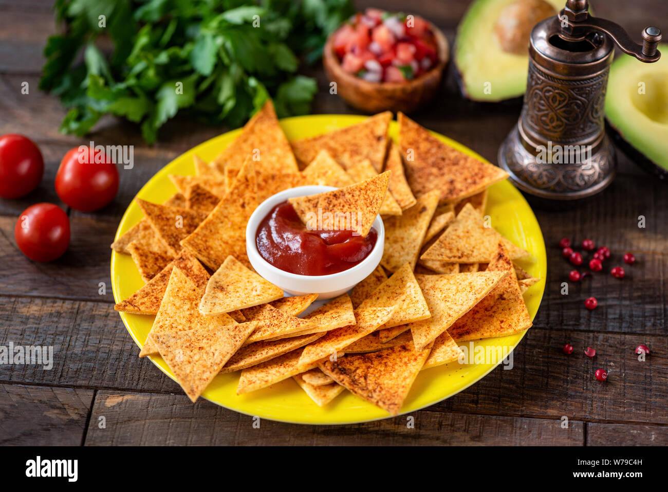 Tortilla Chips, Nachos mit Paprika und Tomaten Soße auf einer hölzernen Tisch Hintergrund. Traditionelle mexikanische vegetarische Party Snack oder Vorspeise Stockfoto