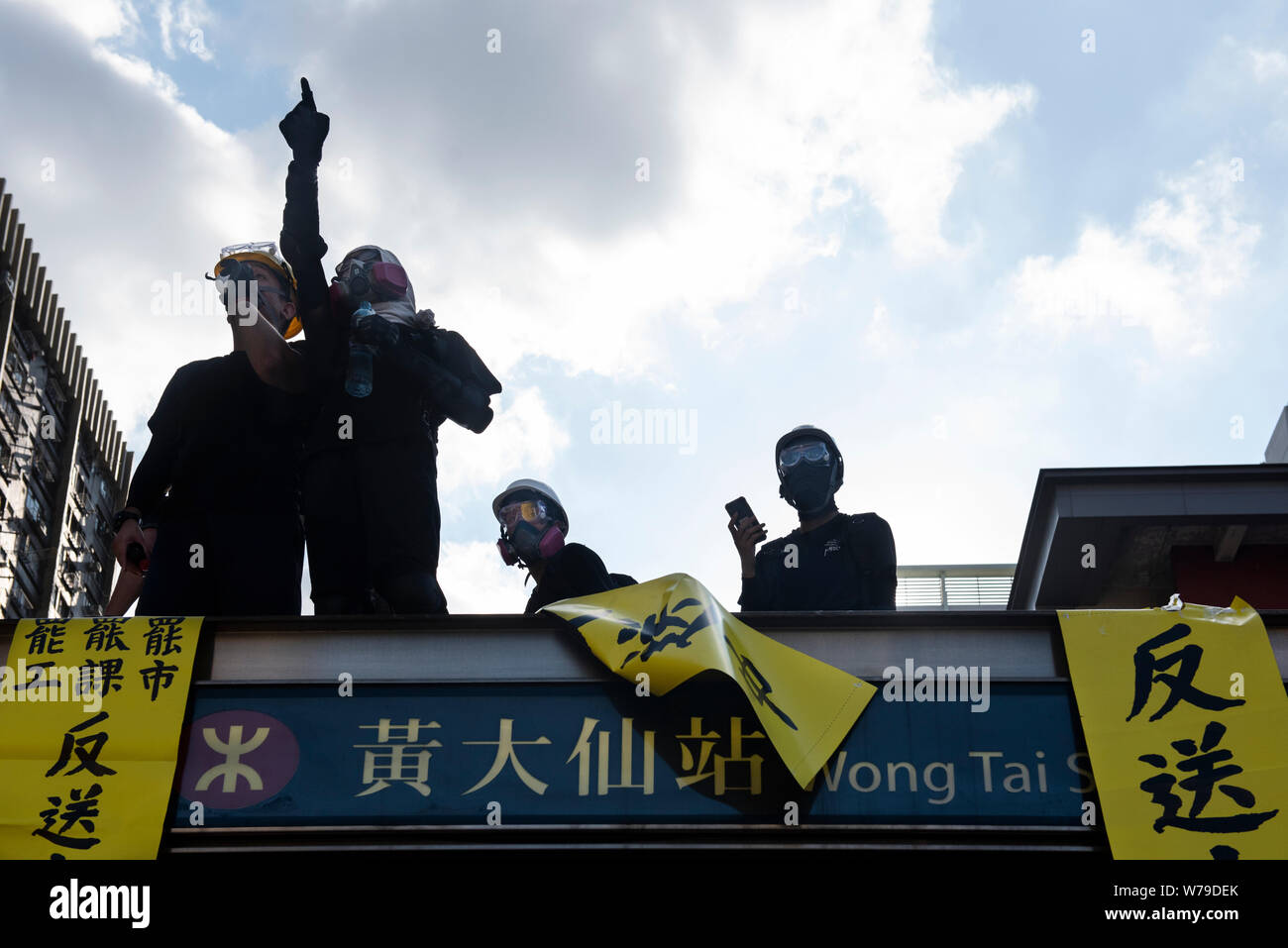 Eine Demonstrantin Punkte an die Polizei während der Demonstration. Die Unruhen in Hongkong fort, als die Demonstranten die Asienkrise Nabe nach unten mit einem Generalstreik am Montag nach einer 9. gerade Wochenende von Protesten gegen die Regierung verschoben. Der Generalstreik hat bewirkt, dass die öffentlichen Verkehrsmittel bietet nur eingeschränkte Services aufgrund von Personalmangel. Hunderte Flüge fliegen in und aus dem Internationalen Flughafen Hong Kong alle abgesagt worden als Zahlen der Flugsicherung Personal war in den Streik. Stockfoto