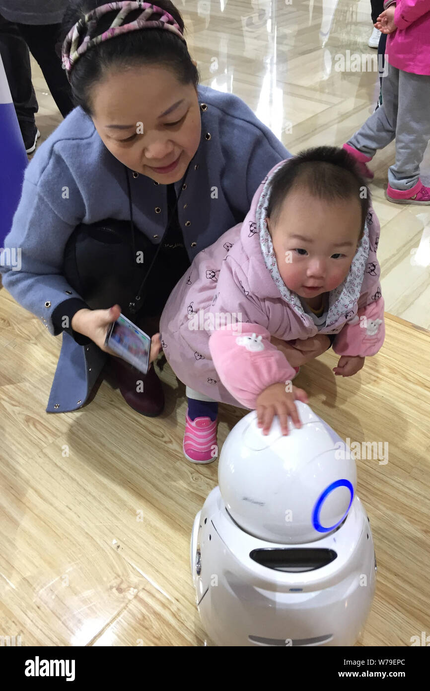 Ein Kind interagiert mit einem Roboter während der China Optics Valley International AI Industrie Gipfel 2017 in Wuhan City, Zentrale der chinesischen Provinz Hubei, 19. Stockfoto