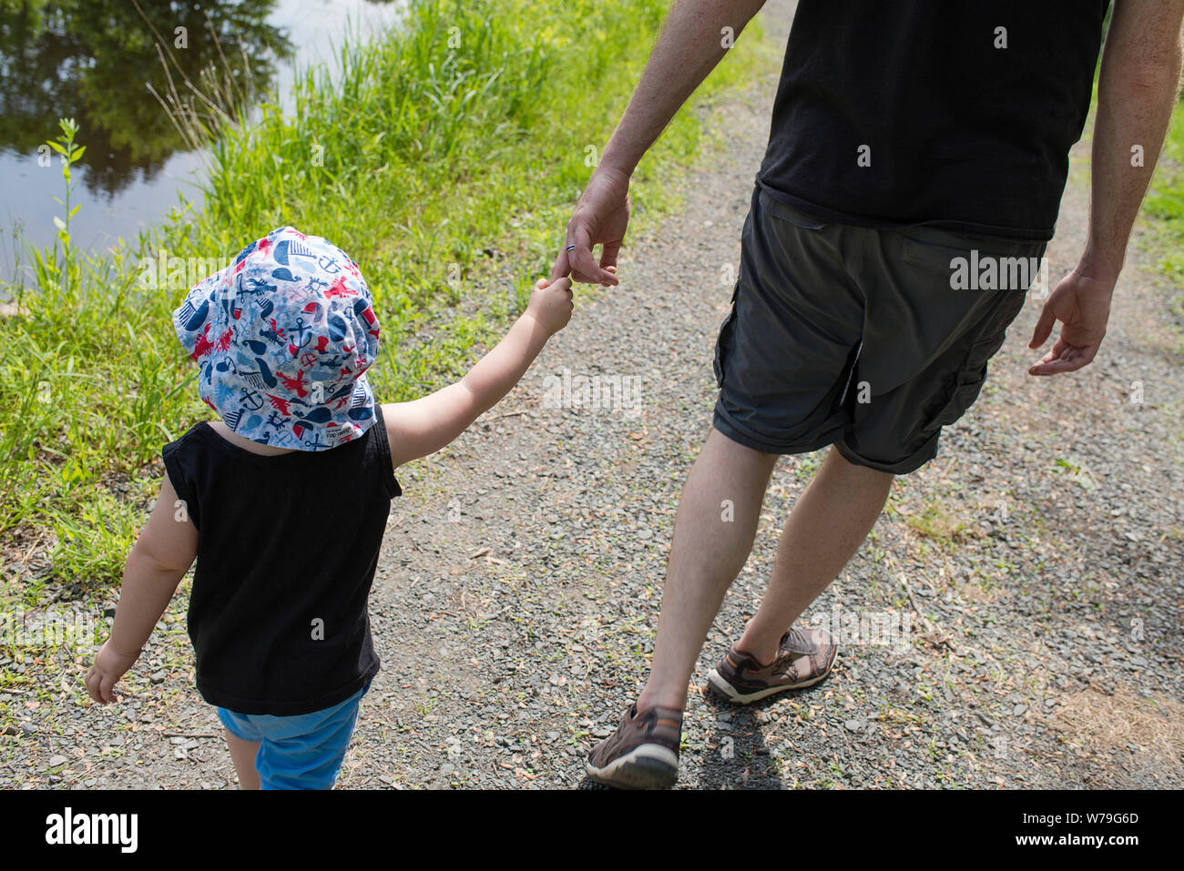 Vater und Sohn gehen an einem See. Stockfoto