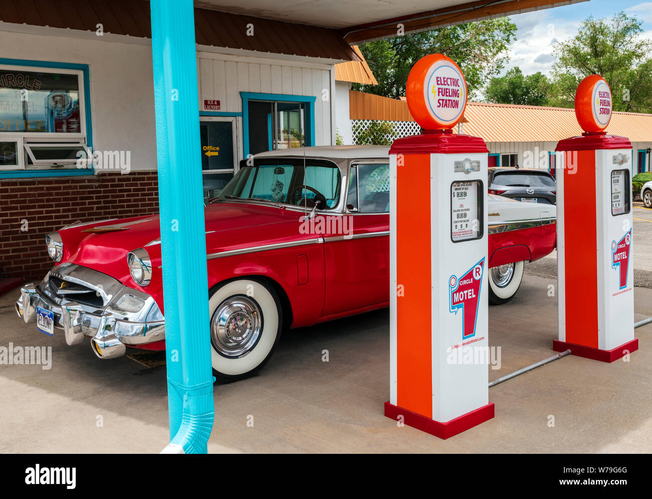 1955 Studebaker President classic car Vor antiken Gaspumpen geparkt SFF konvertiert zu Elektroauto Ladegeräte; den Kreis R Motel; Salida, Colorado, USA Stockfoto
