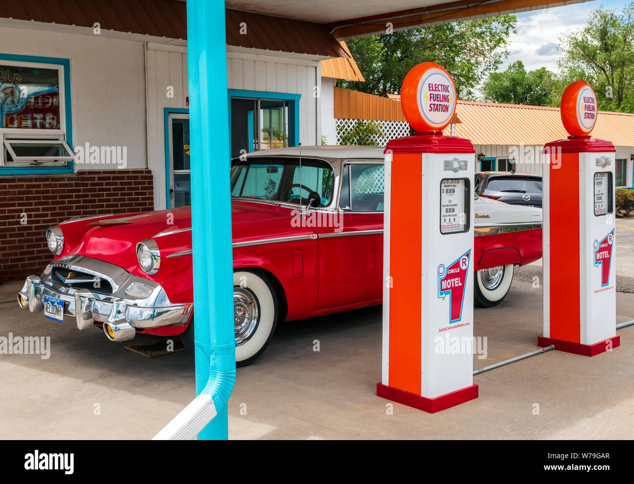 1955 Studebaker President classic car Vor antiken Gaspumpen geparkt SFF konvertiert zu Elektroauto Ladegeräte; den Kreis R Motel; Salida, Colorado, USA Stockfoto