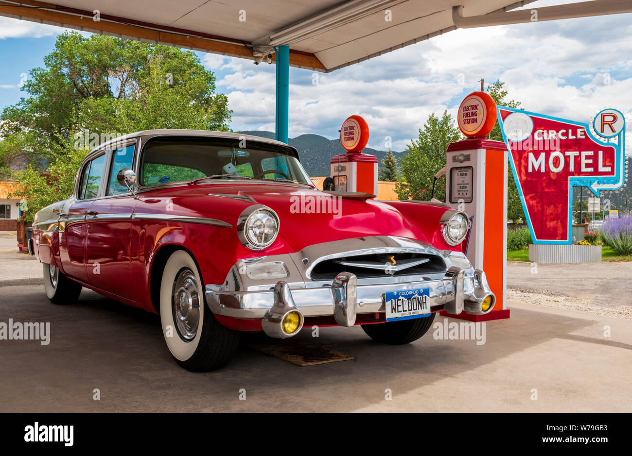 1955 Studebaker President classic car Vor antiken Gaspumpen geparkt SFF konvertiert zu Elektroauto Ladegeräte; den Kreis R Motel; Salida, Colorado, USA Stockfoto