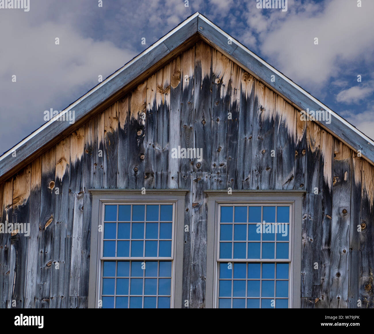 Neue Fenster für einen alten verwitterten Scheune zeigen auch den Abbau von Holz zu das Wetter unter dem geschützten Dach überstand ausgesetzt. Stockfoto