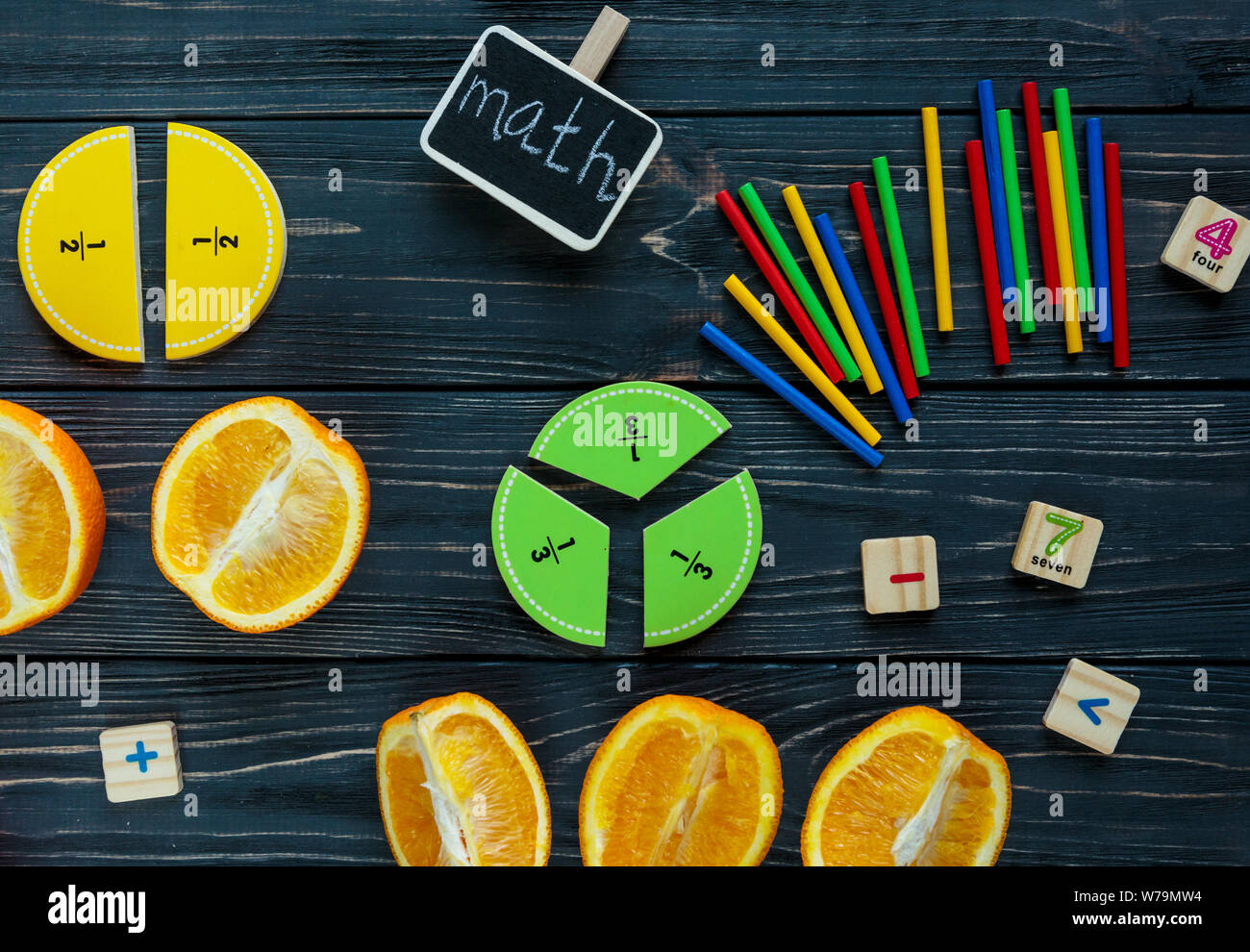 Сolorful mathe Fraktionen und Orangen als Probe auf dunklem Hintergrund oder Tabelle. Interessante kreative lustige Mathe für Kids. Bildung, zurück zu schoo Stockfoto
